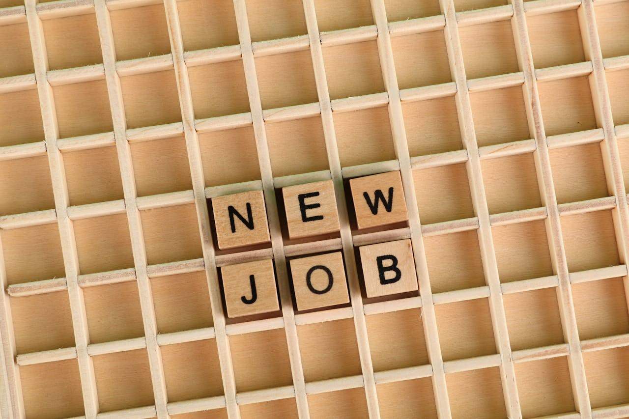 portfolio-06 Discover the excitement of a new job with wooden letter tiles spelling 'NEW JOB' on a grid.